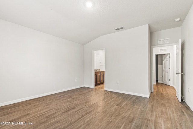 unfurnished room with vaulted ceiling and light hardwood / wood-style floors