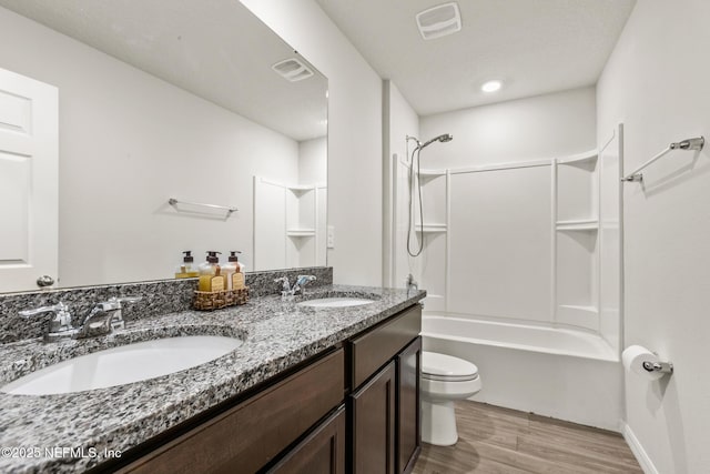 full bathroom featuring vanity, hardwood / wood-style flooring, toilet, and shower / bath combination