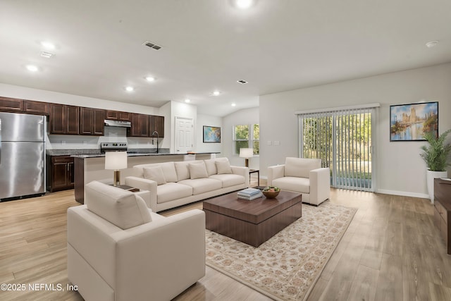 living room with lofted ceiling and light hardwood / wood-style flooring