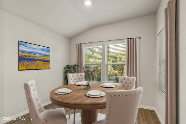 dining area with lofted ceiling and hardwood / wood-style floors