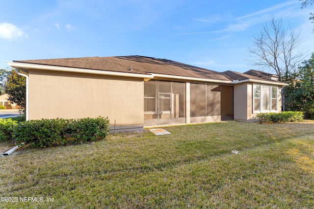 back of house featuring a yard and a sunroom