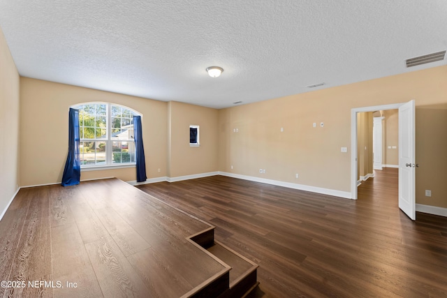 empty room featuring dark hardwood / wood-style floors and a textured ceiling