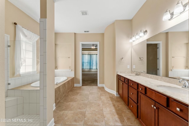 bathroom featuring ceiling fan, vanity, plus walk in shower, and tile patterned flooring