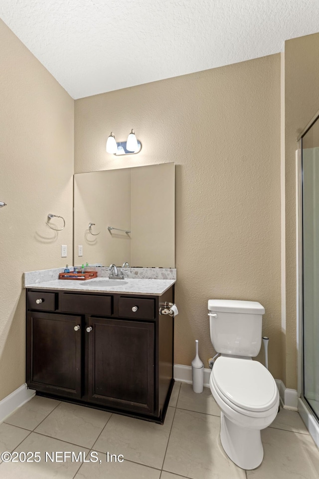 bathroom with tile patterned flooring, toilet, vanity, and a shower with shower door