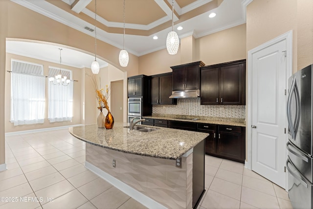 kitchen featuring appliances with stainless steel finishes, sink, an island with sink, and hanging light fixtures