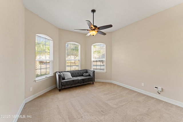 living area with light colored carpet and ceiling fan