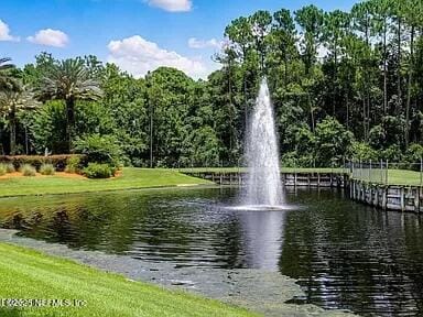 view of home's community with a water view and a yard