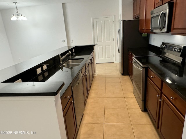 kitchen featuring light tile patterned flooring, sink, an inviting chandelier, pendant lighting, and stainless steel appliances