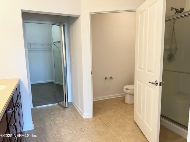 bathroom featuring vanity, tile patterned floors, toilet, and walk in shower