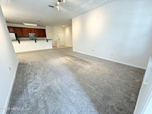 unfurnished living room featuring carpet floors and a textured ceiling