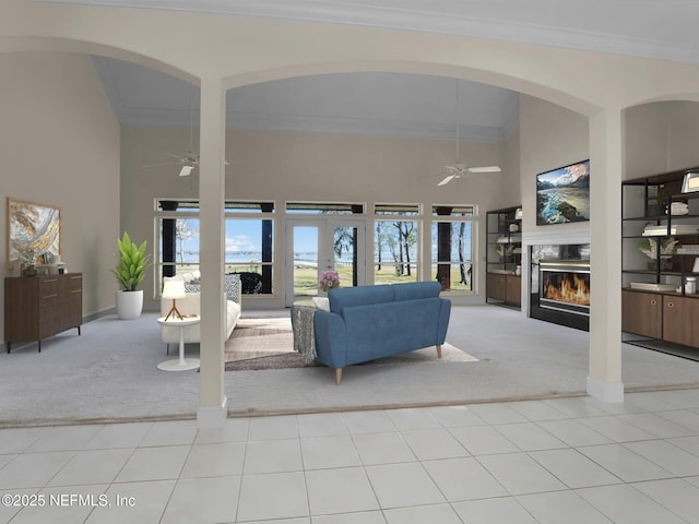 unfurnished living room featuring a towering ceiling, light colored carpet, and ceiling fan