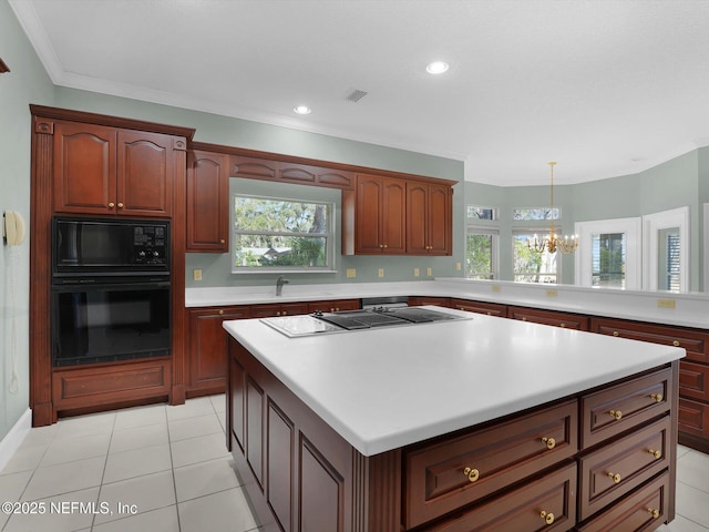 kitchen featuring sink, stovetop, black microwave, a notable chandelier, and pendant lighting