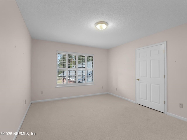 carpeted empty room with a textured ceiling