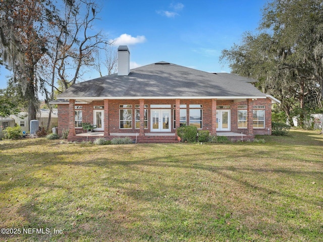 back of property featuring french doors and a lawn