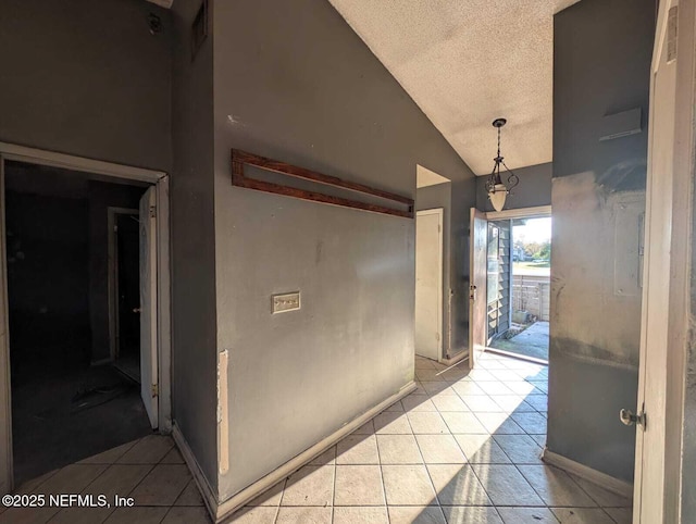 hallway with lofted ceiling and light tile patterned floors