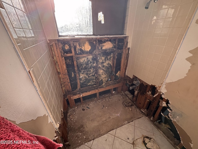 bathroom with tile patterned floors and tile walls