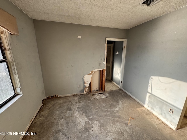 spare room with a textured ceiling