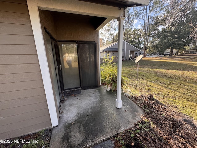 view of exterior entry featuring a lawn