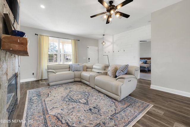 living room featuring ceiling fan and dark hardwood / wood-style flooring