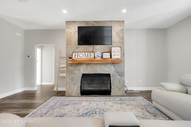 living room with dark hardwood / wood-style flooring and a fireplace