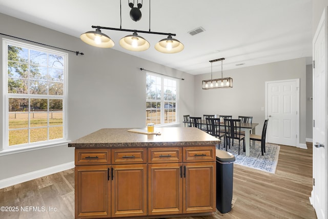 kitchen featuring pendant lighting, light hardwood / wood-style floors, and a center island