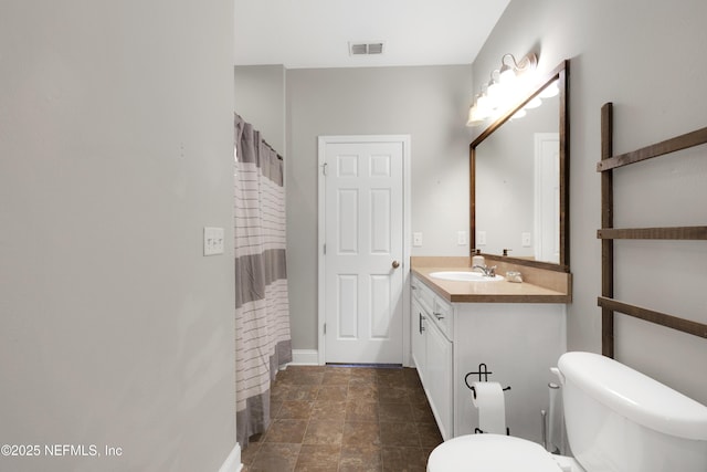 bathroom featuring vanity, curtained shower, and toilet