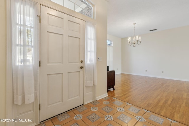 foyer entrance featuring tile patterned flooring and a notable chandelier