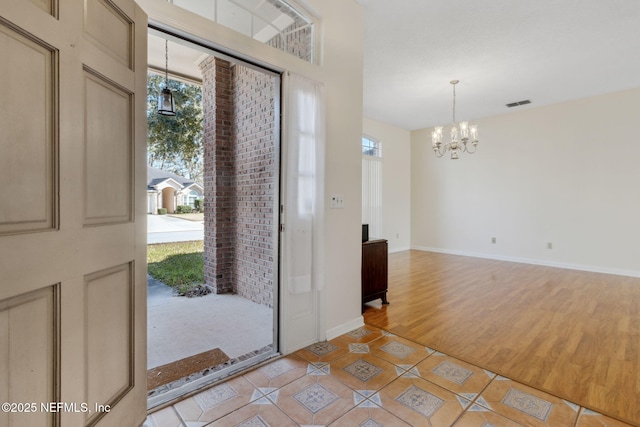 tiled foyer entrance with a notable chandelier