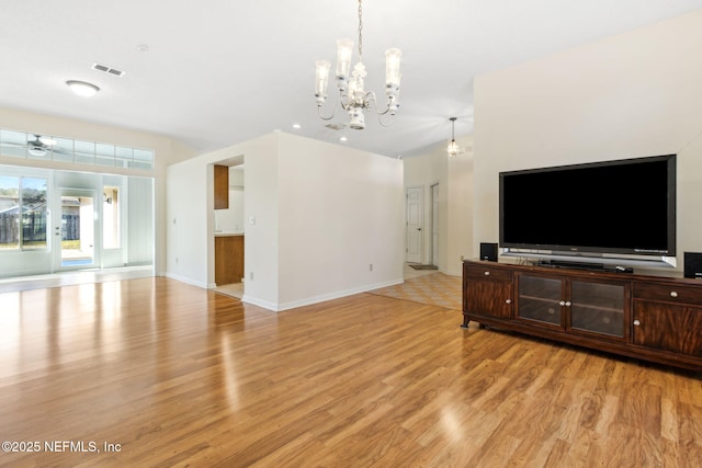 living room featuring ceiling fan with notable chandelier and light hardwood / wood-style floors