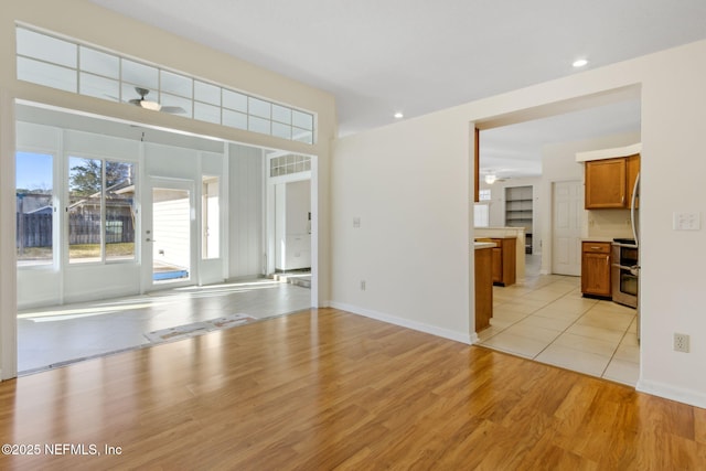 unfurnished living room featuring light hardwood / wood-style flooring and ceiling fan