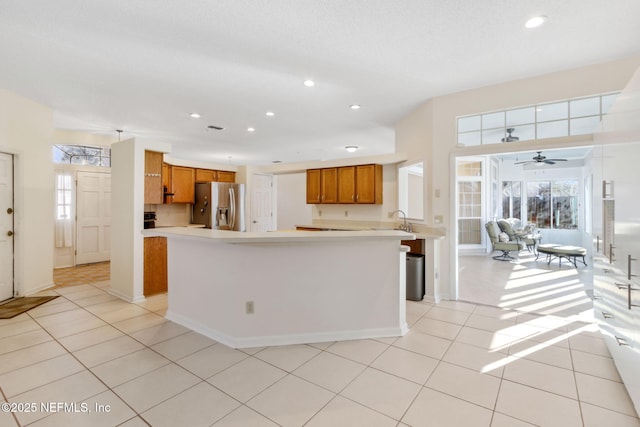 kitchen with stainless steel refrigerator with ice dispenser, sink, and light tile patterned floors