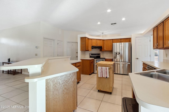 kitchen featuring appliances with stainless steel finishes, a breakfast bar, and light tile patterned floors