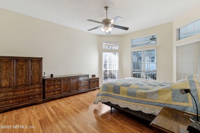 bedroom featuring ceiling fan, a textured ceiling, and light wood-type flooring