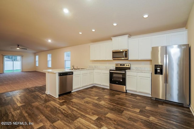 kitchen with stainless steel appliances, dark wood-type flooring, white cabinets, and kitchen peninsula