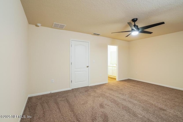 unfurnished room with ceiling fan, light carpet, and a textured ceiling