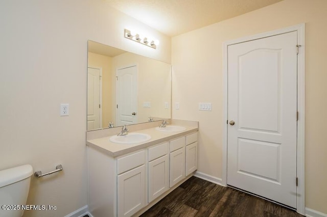 bathroom with vanity, toilet, and hardwood / wood-style floors