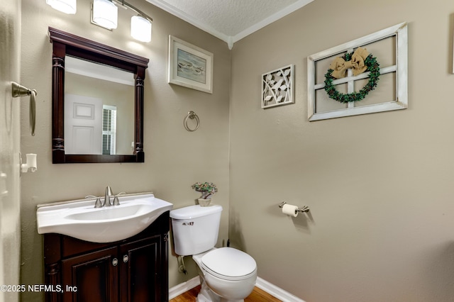 bathroom with vanity, ornamental molding, a textured ceiling, and toilet