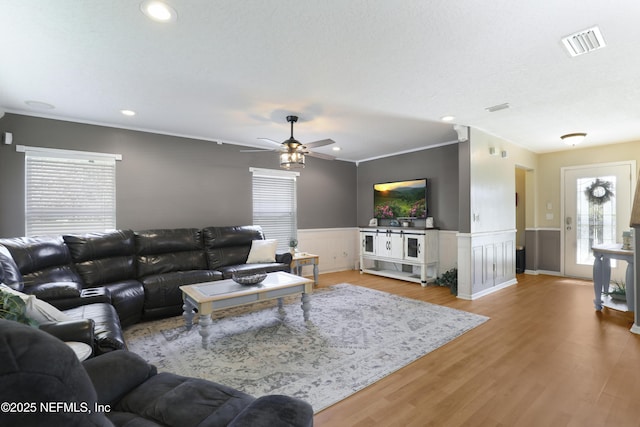 living room with crown molding, hardwood / wood-style floors, a textured ceiling, and ceiling fan