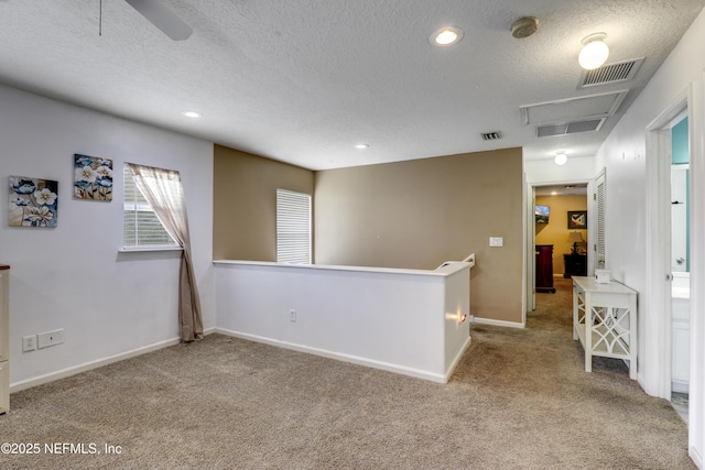 carpeted spare room with ceiling fan and a textured ceiling