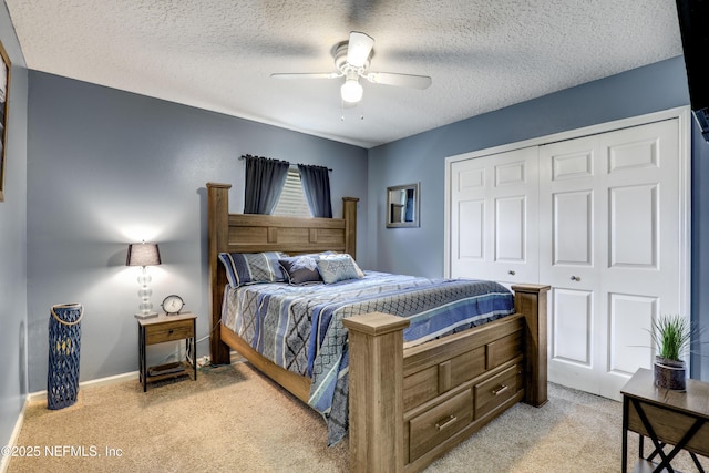 carpeted bedroom featuring ceiling fan, a closet, and a textured ceiling