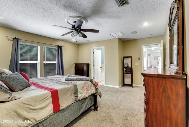 carpeted bedroom featuring ceiling fan, ensuite bath, and a textured ceiling