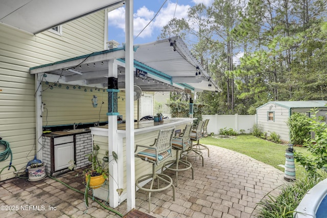 view of patio / terrace with a shed and exterior bar