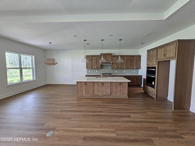 101 Erlking Ct, Saint Johns, FL 32259 - kitchen featuring light countertops, dark wood-type flooring, backsplash, a kitchen island with sink, and open floor plan