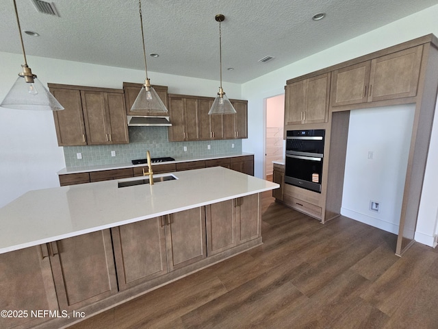 101 Erlking Ct, Saint Johns, FL 32259 - kitchen with dark wood-style flooring, decorative backsplash, gas stovetop, a textured ceiling, and light countertops