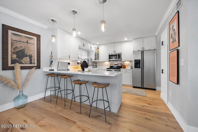 kitchen with white cabinetry, stainless steel appliances, and kitchen peninsula