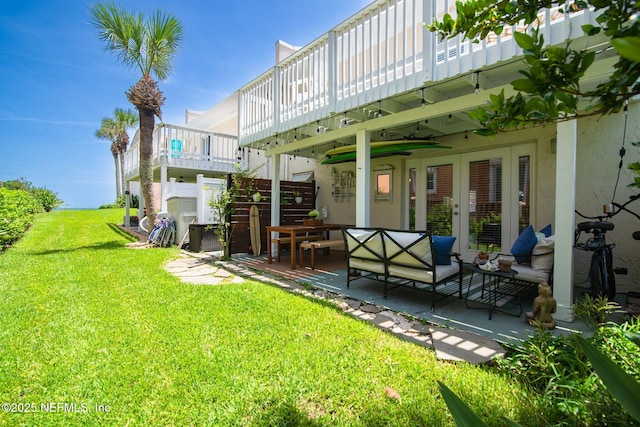 view of yard with french doors, an outdoor living space, and a patio area