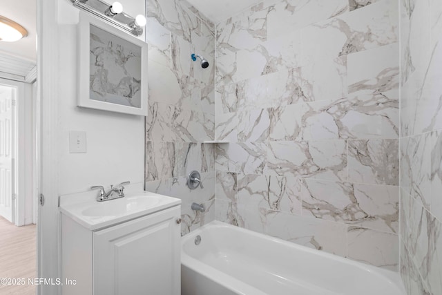 bathroom with tiled shower / bath combo and vanity