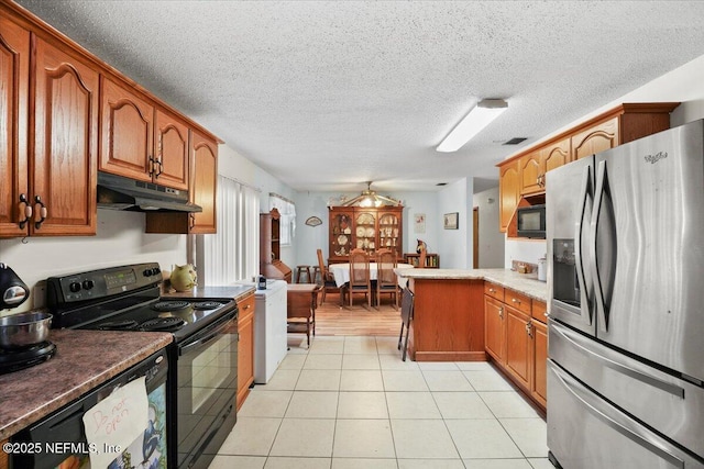 kitchen featuring light tile patterned floors, black appliances, and a textured ceiling