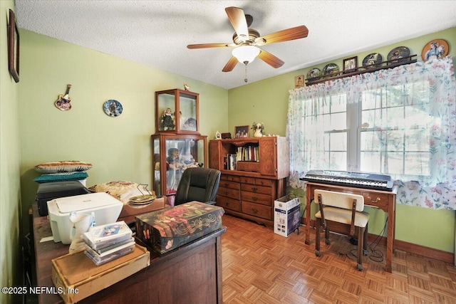 office featuring ceiling fan, parquet flooring, and a textured ceiling