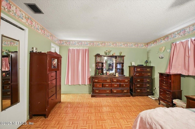 bedroom with light parquet flooring and a textured ceiling